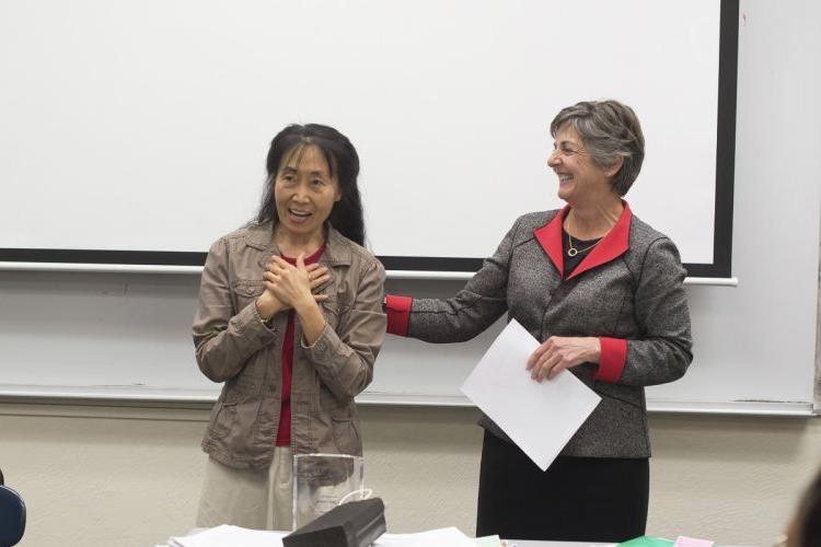 Provost Maria Pallavicini informing Professor Xiaojing 周 that she had won the 2015 Distinguished Faculty Award.