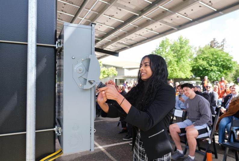 A student "flips the switch" for the solar panels